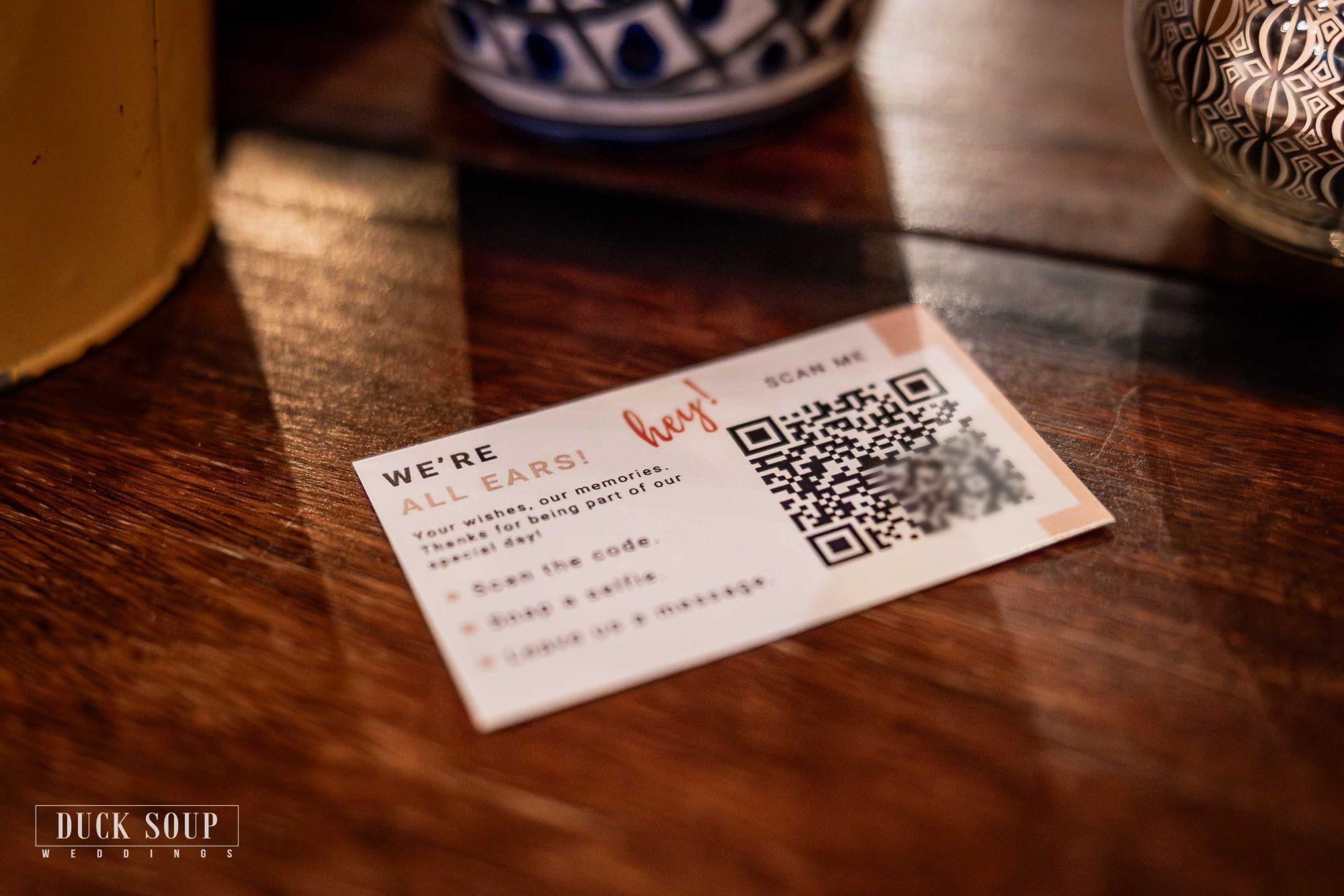 A small “We’re all ears!” QR code card on a wooden table
